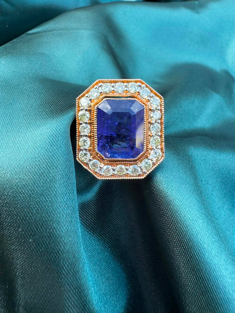 Tanzanite and diamond halo ring in 18ct rose gold, top view showing emerald-cut tanzanite in octagonal diamond halo