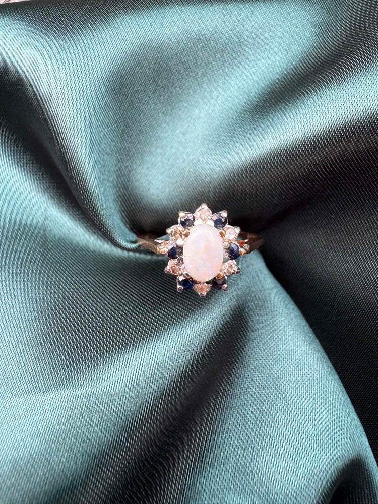 Opal, diamond and gem cluster ring in 9ct yellow gold, front view showing opal centre stone