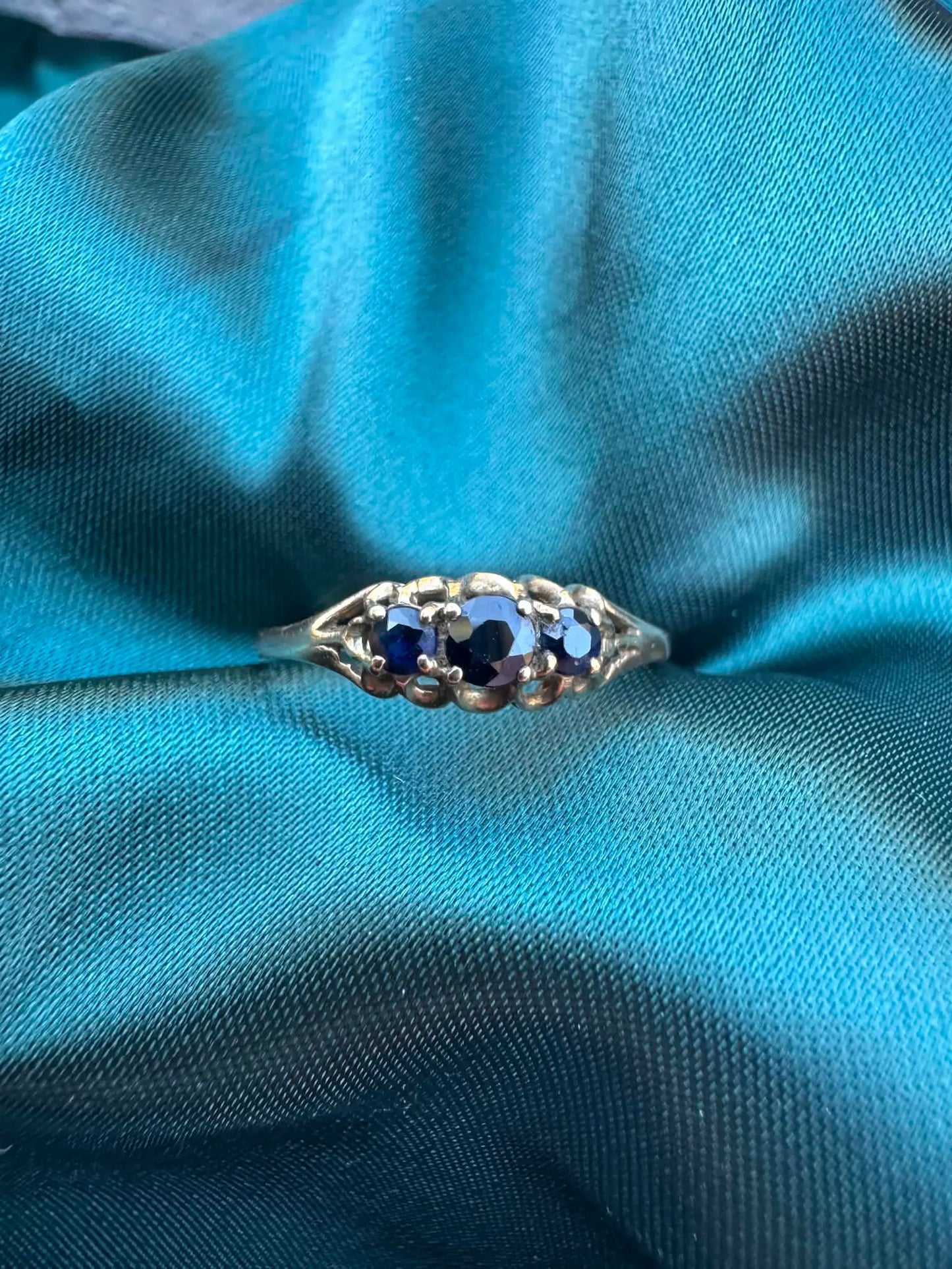 Blue sapphire three-stone ring in 9ct yellow gold, top view