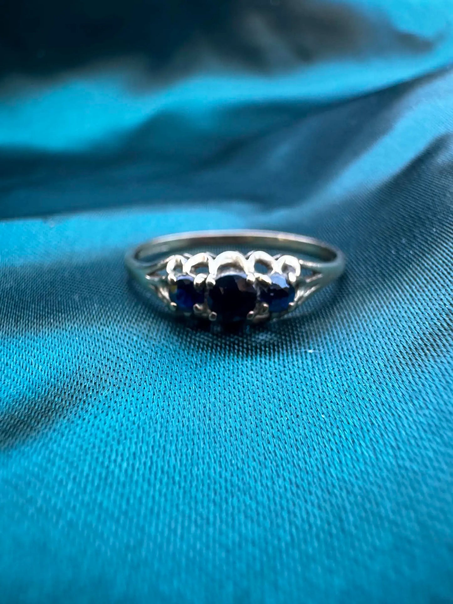 Blue sapphire three-stone ring in 9ct yellow gold, front view