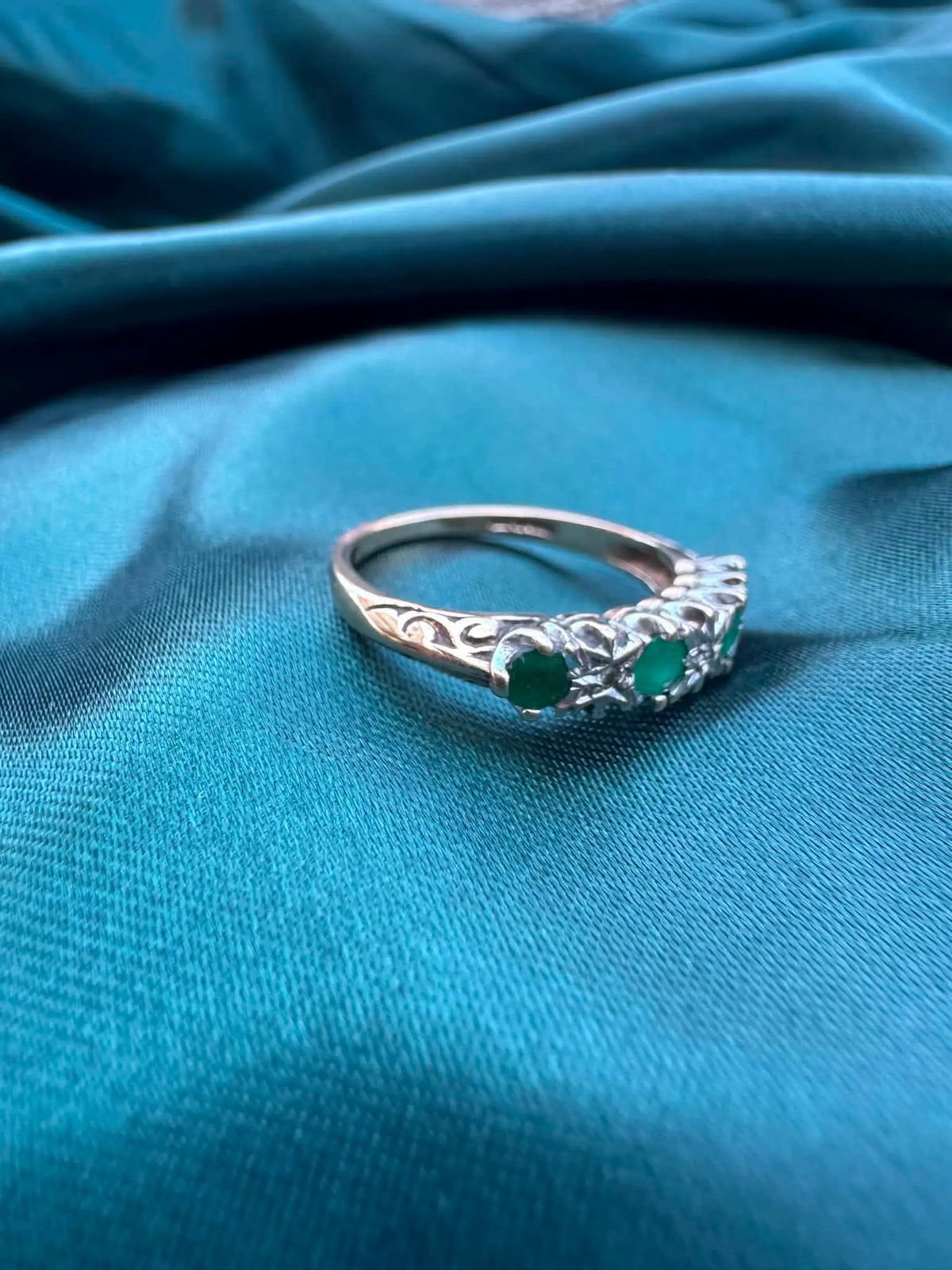 Diamond and emerald ring in 9ct gold, side view showing band detail