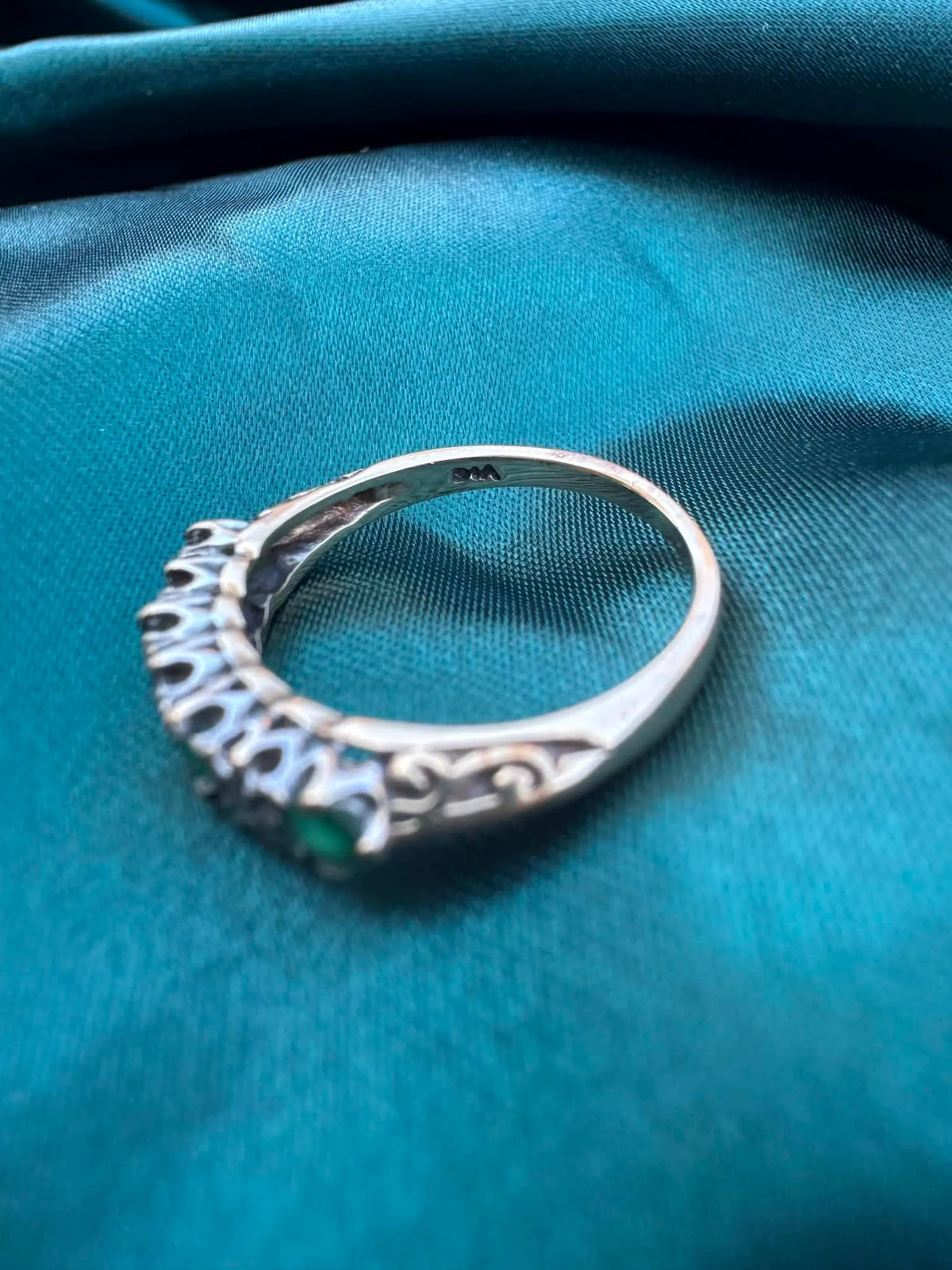 Diamond and emerald ring in 9ct gold, side profile view showing band