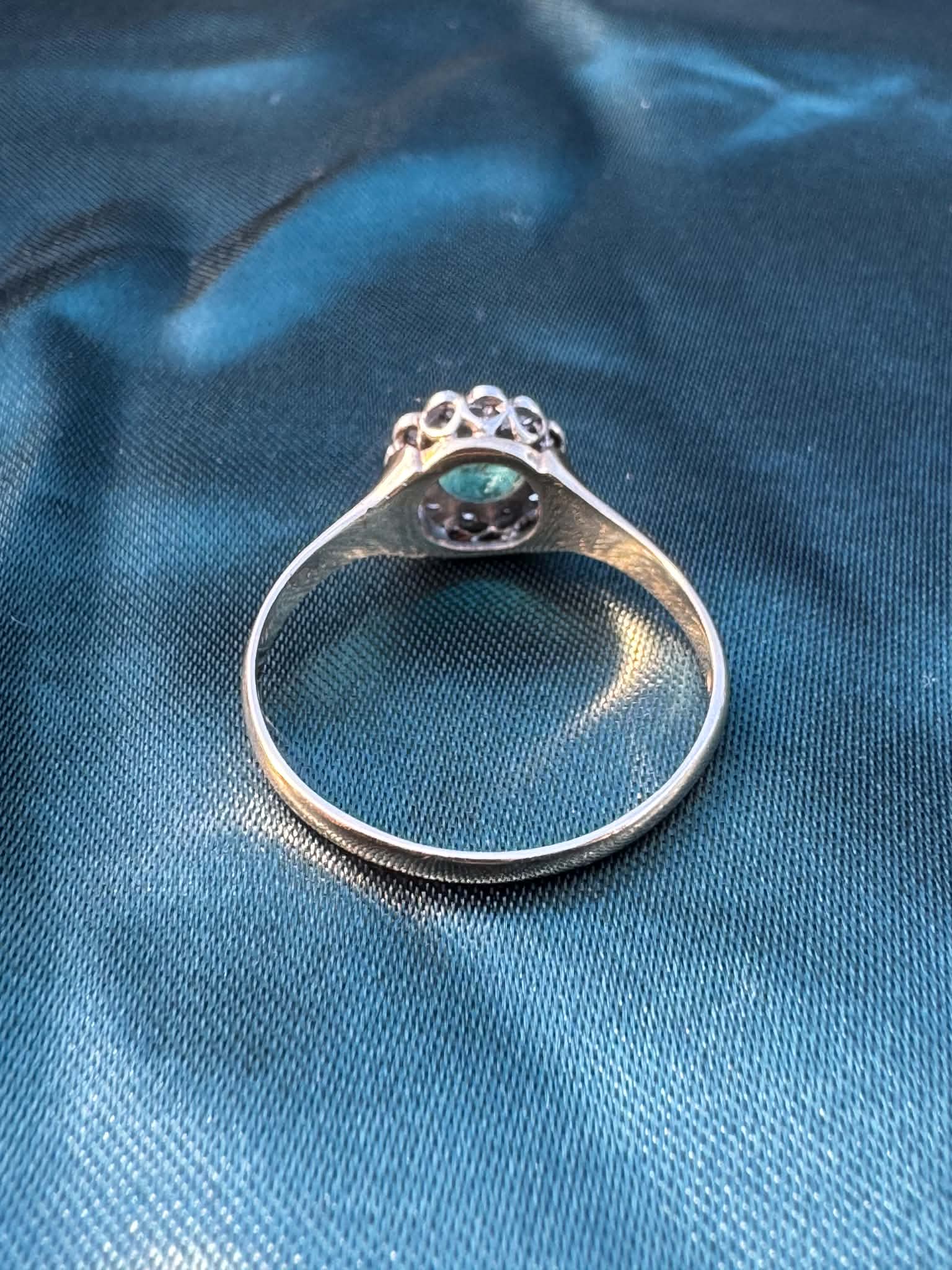 Emerald and diamond halo ring in 9ct yellow gold, reverse side showing gold band interior