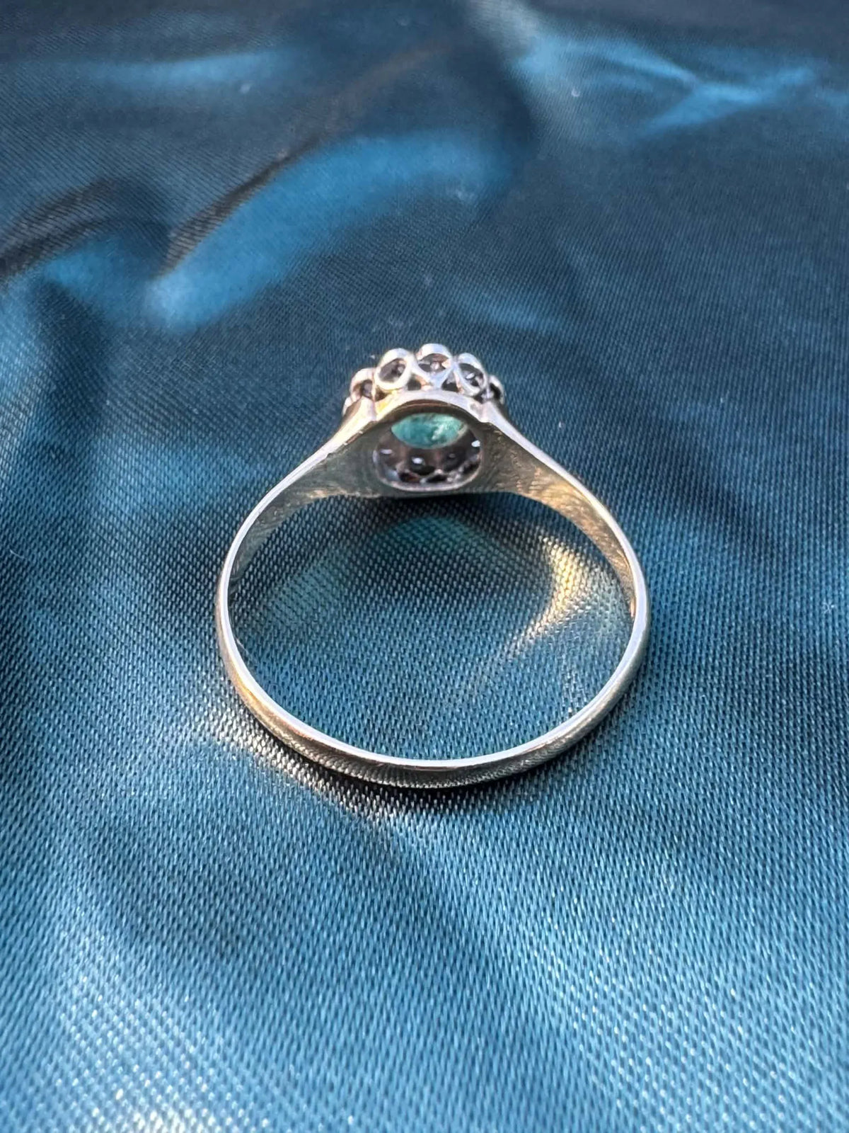 Emerald and diamond halo ring in 9ct yellow gold, reverse side showing gold band interior