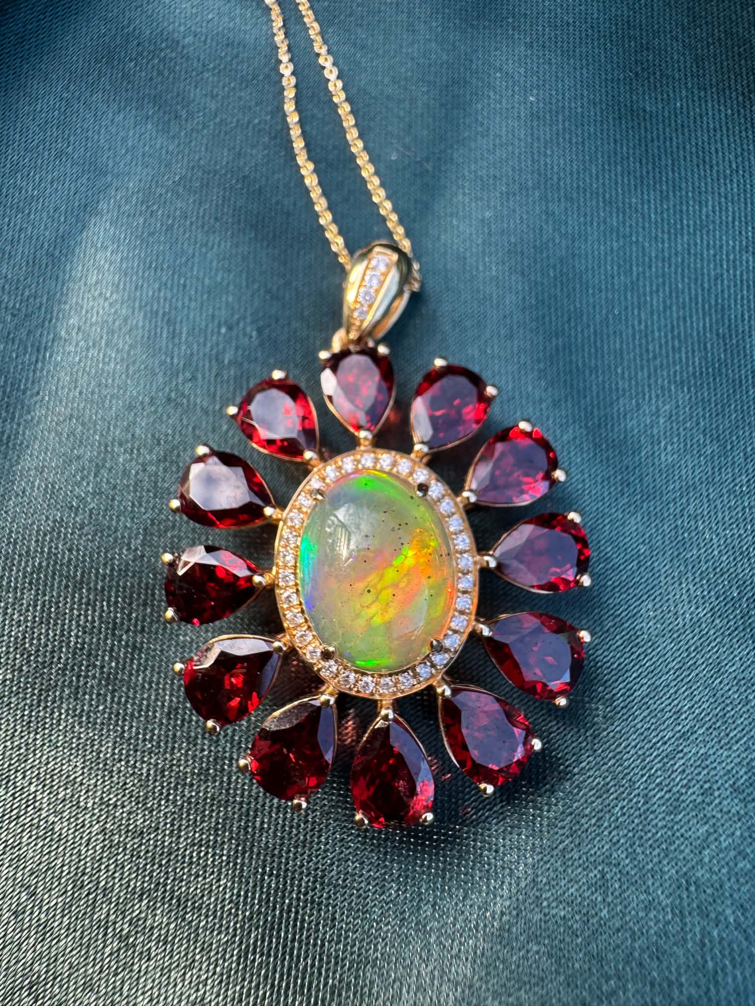 Opal, Garnet & Diamond Pendant in 14ct Gold with oval opal surrounded by garnets and diamond accents