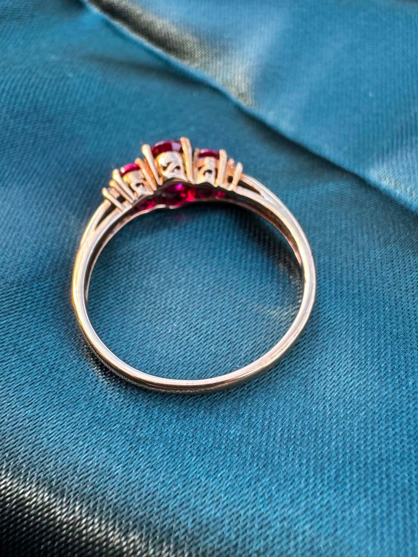 Ruby and diamond trilogy ring in 9ct yellow gold, angled reverse view showing gold band