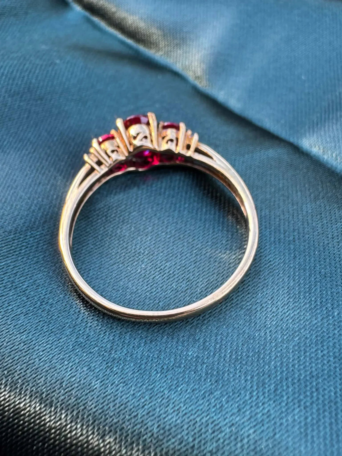 Ruby and diamond trilogy ring in 9ct yellow gold, angled reverse view showing gold band