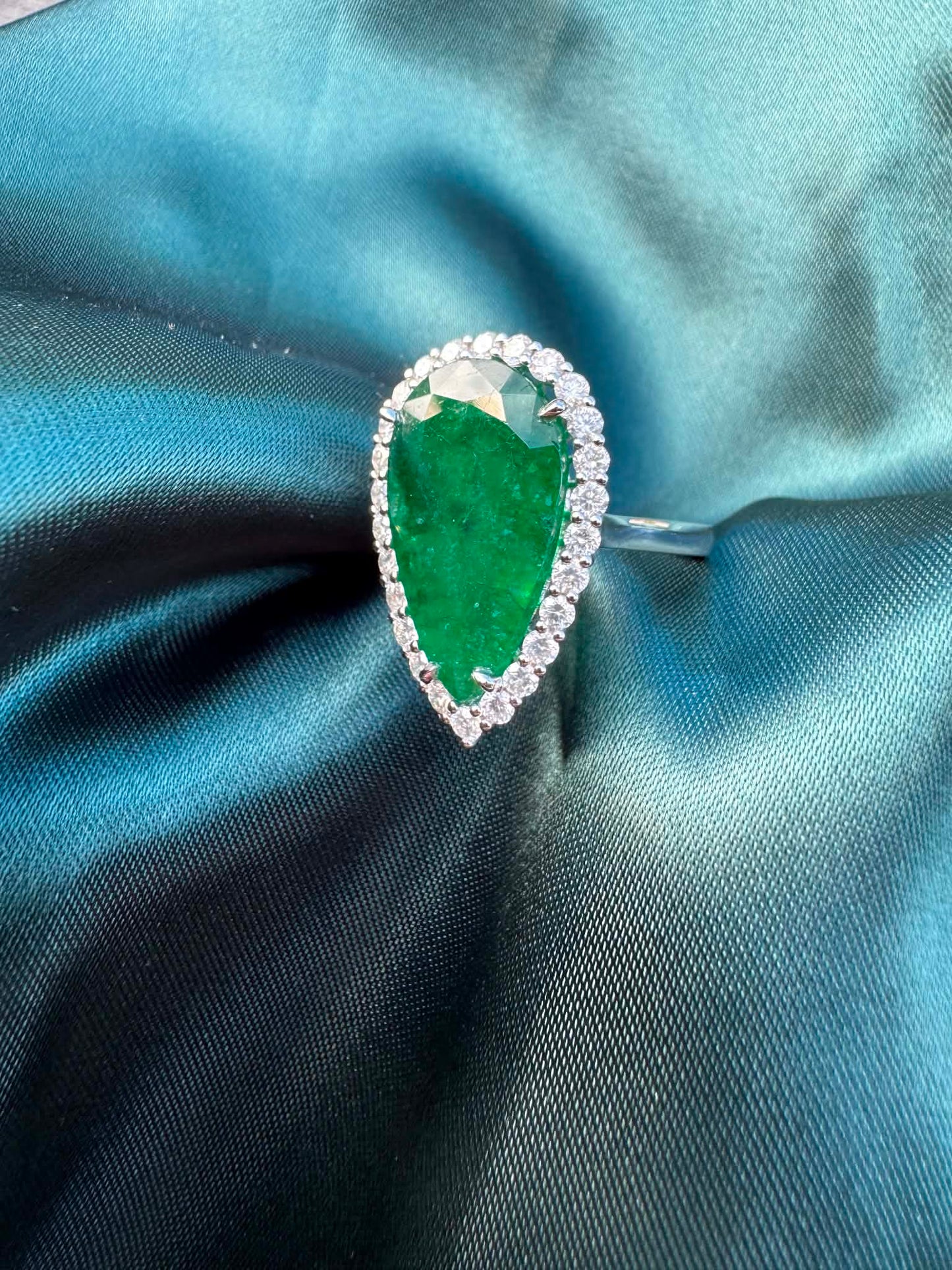 8.28ct pear emerald and diamond halo ring in platinum, angled view