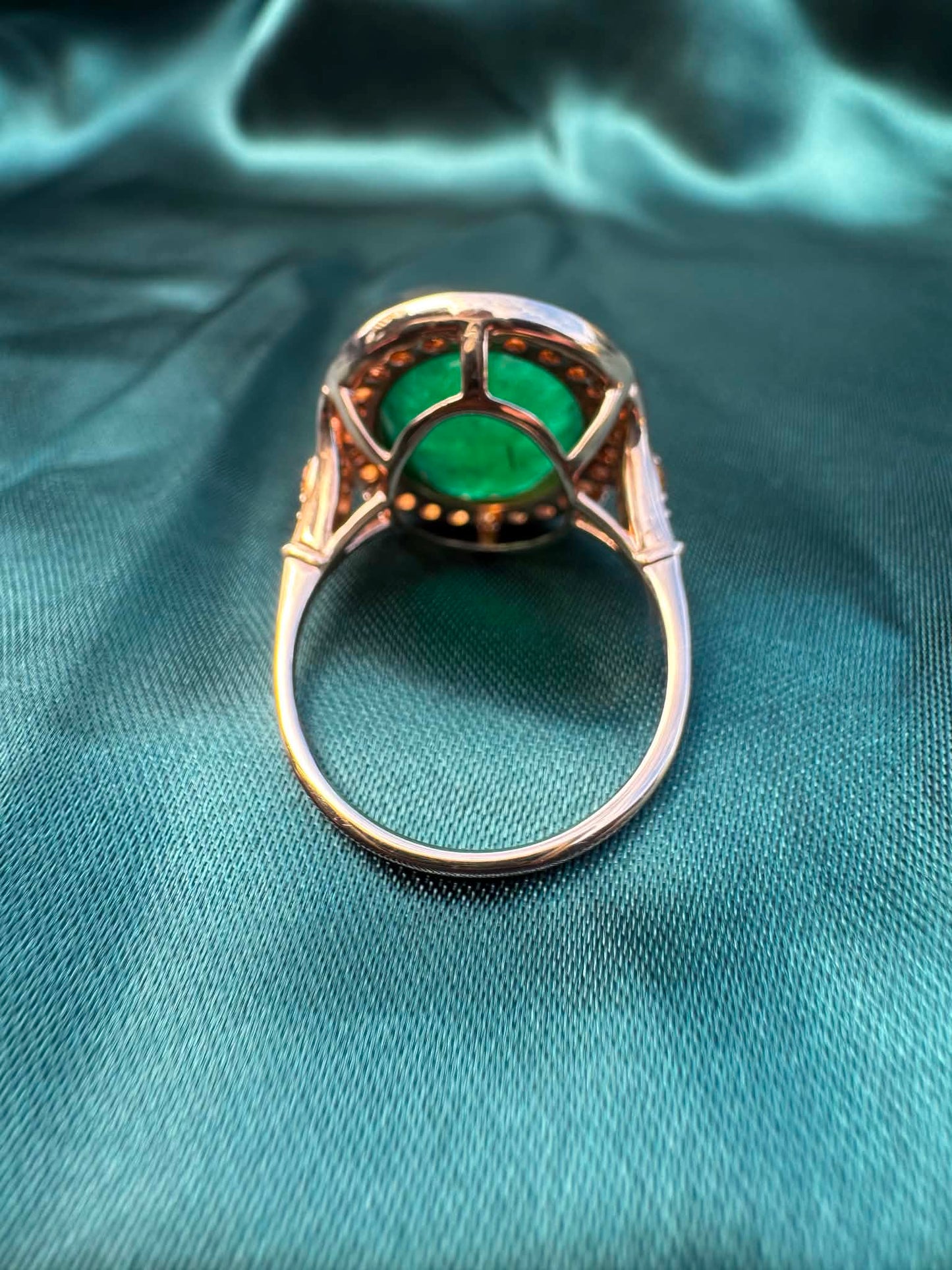 Emerald and orange sapphire cocktail ring in 14ct rose gold, underside view showing basket setting