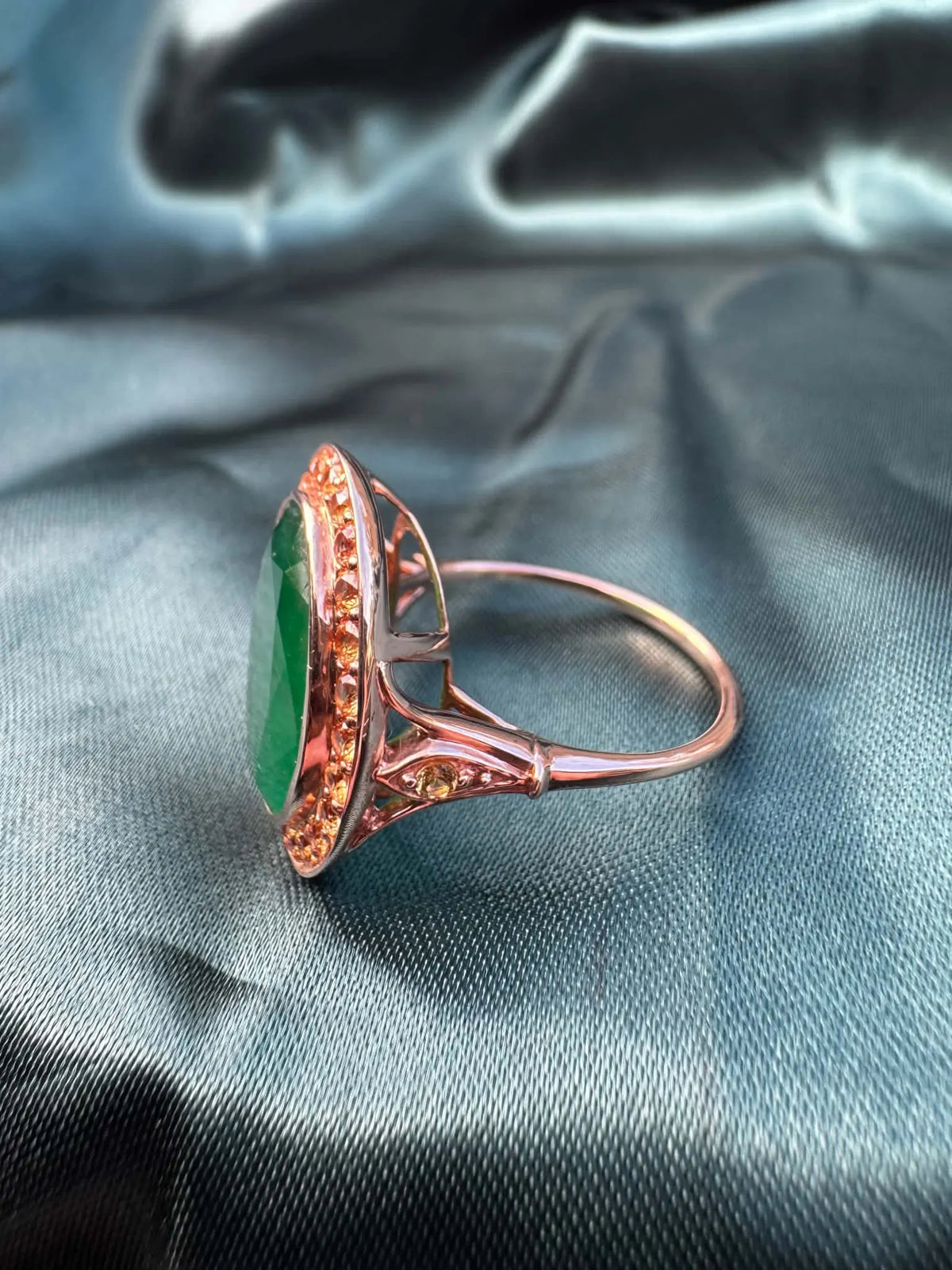 Emerald and orange sapphire cocktail ring in 14ct rose gold, side profile showing band