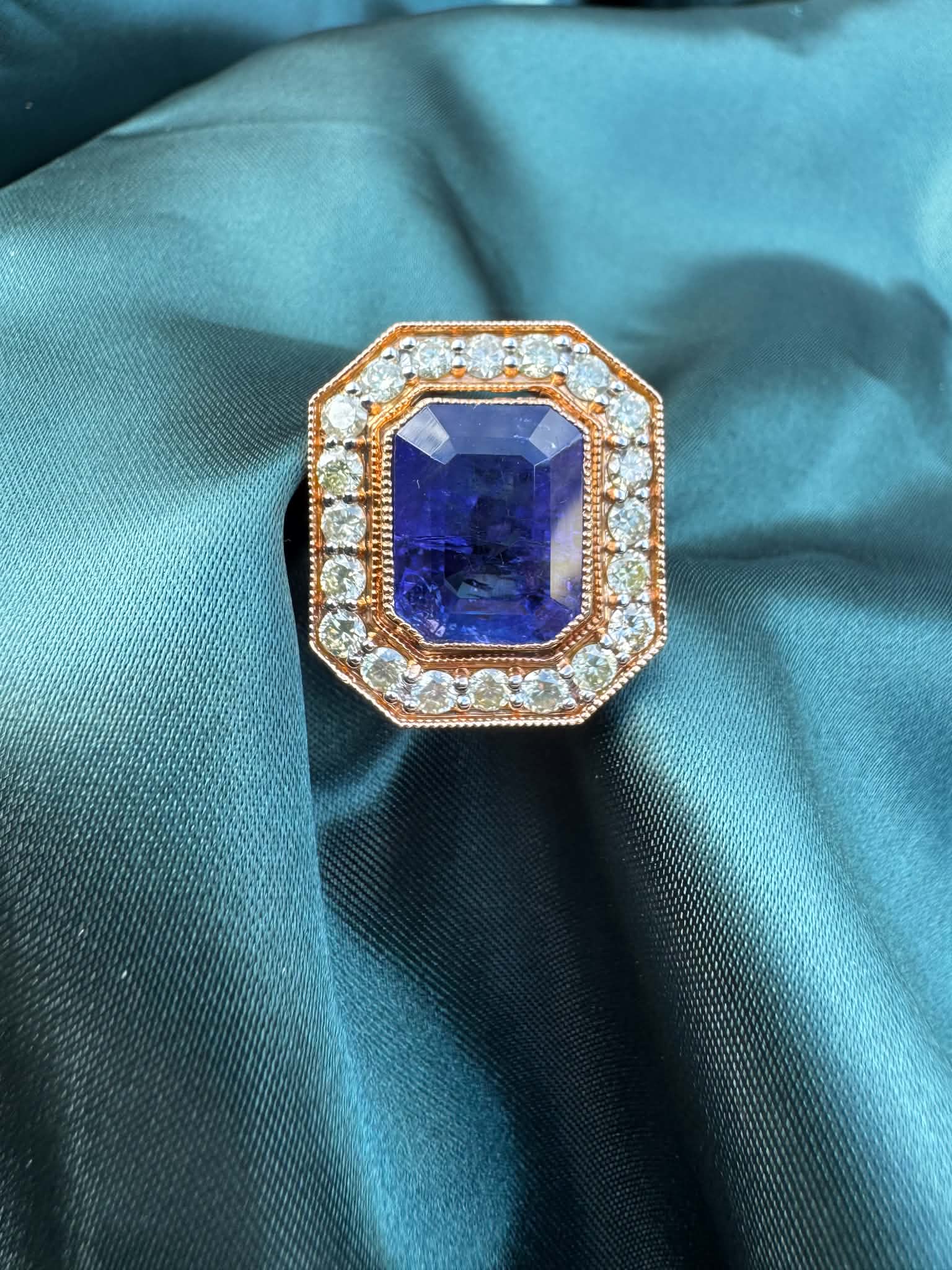 Tanzanite and diamond halo ring in 18ct rose gold, top view showing emerald-cut tanzanite in octagonal diamond halo