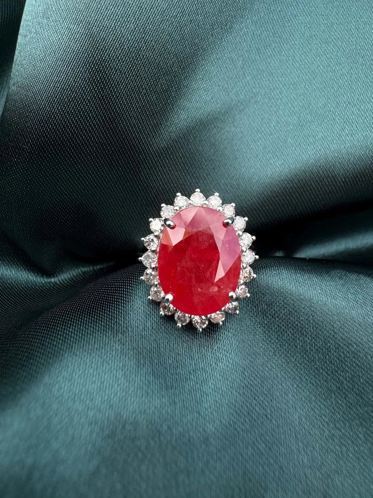 Ruby and diamond halo ring in platinum, top-down view showing oval ruby and diamond halo