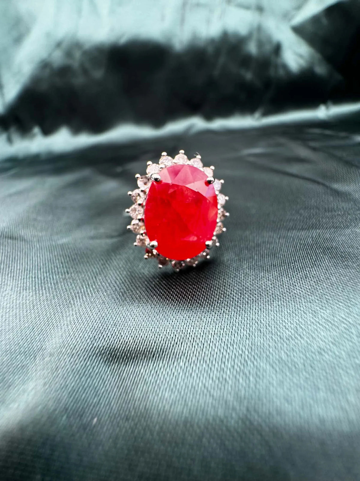 Ruby and diamond halo ring in platinum, close-up showing oval ruby and diamond halo detail