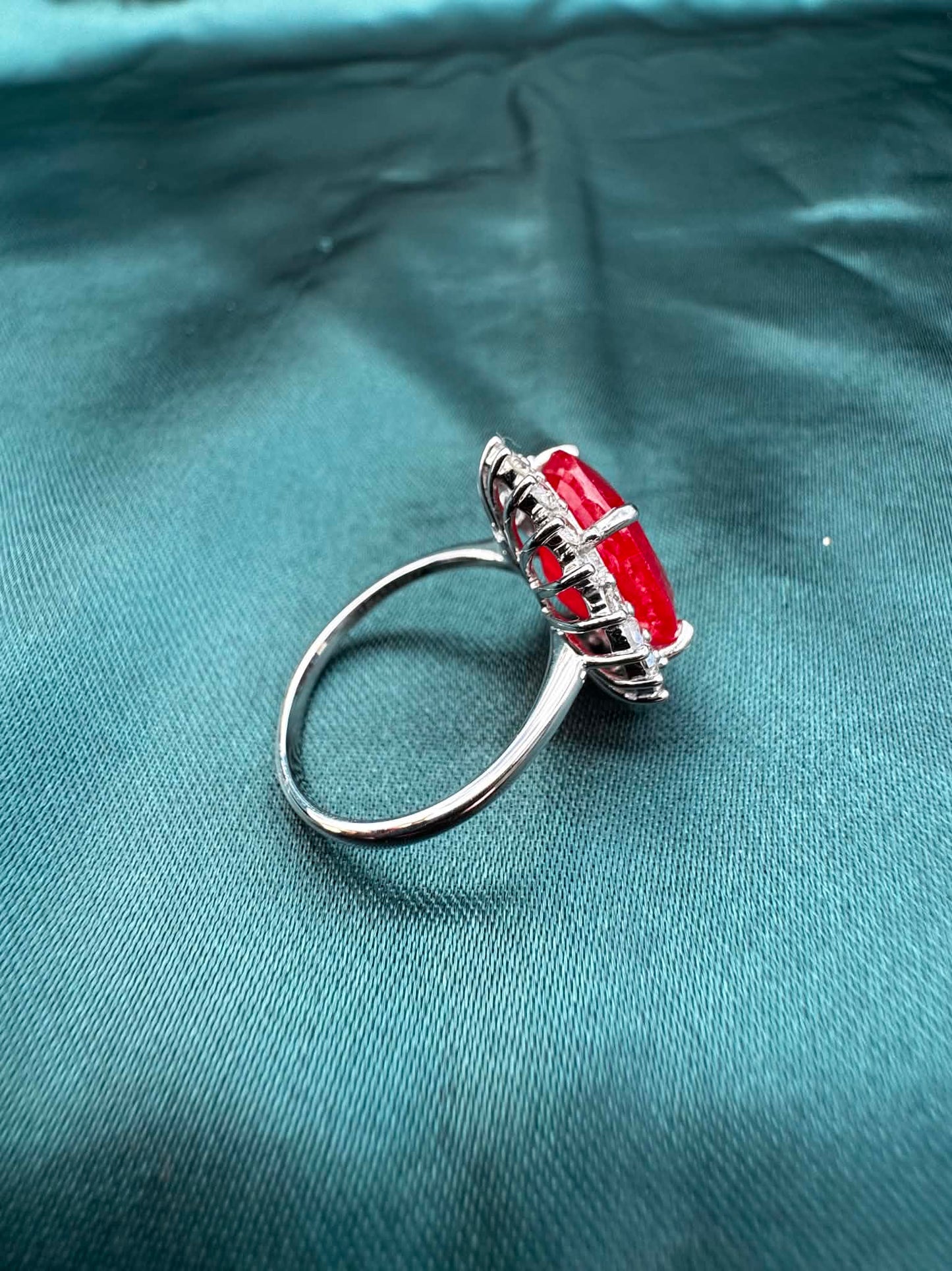 Ruby and diamond halo ring in platinum, side view showing band profile and wire basket setting