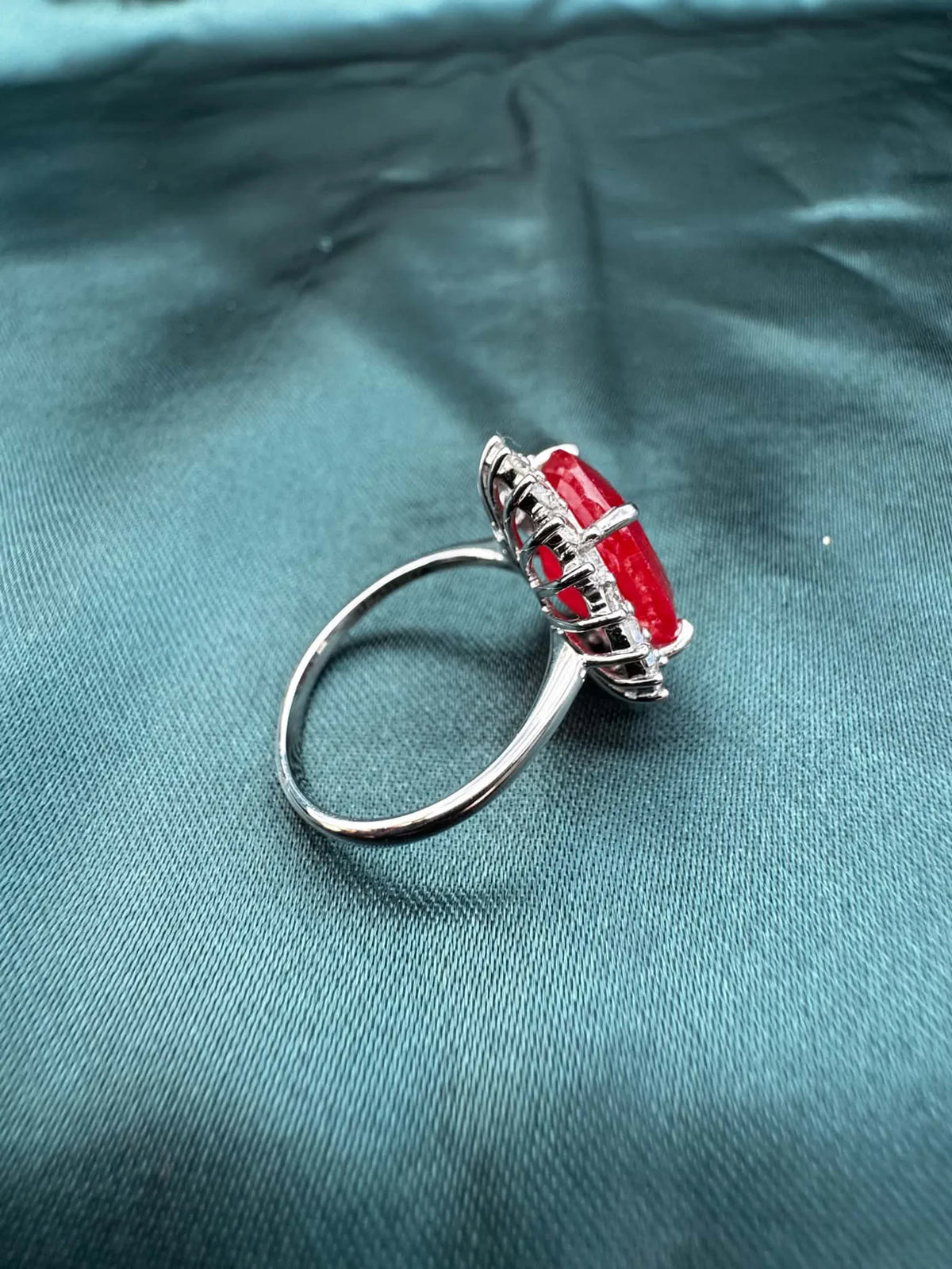 Ruby and diamond halo ring in platinum, side view showing band profile and wire basket setting