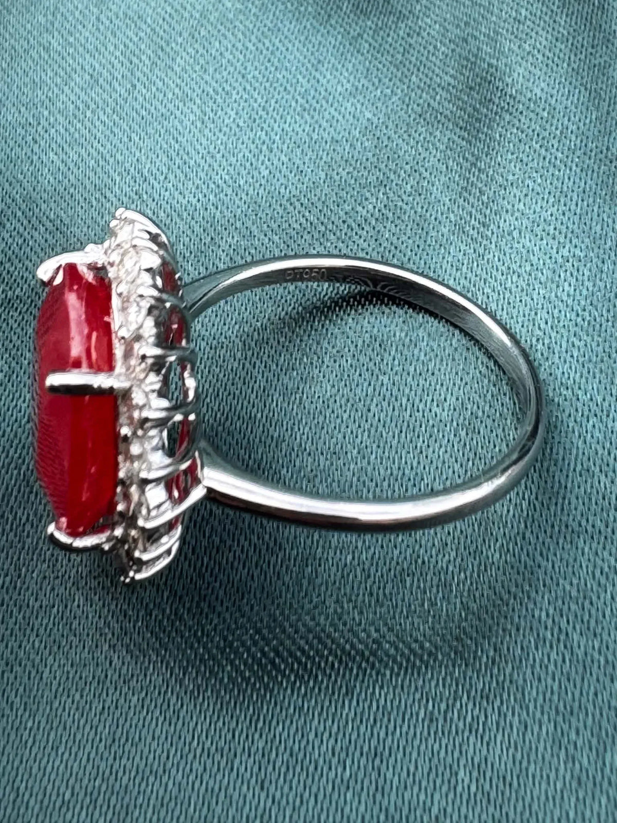 Ruby and diamond halo ring in platinum, side profile showing band and wire basket setting