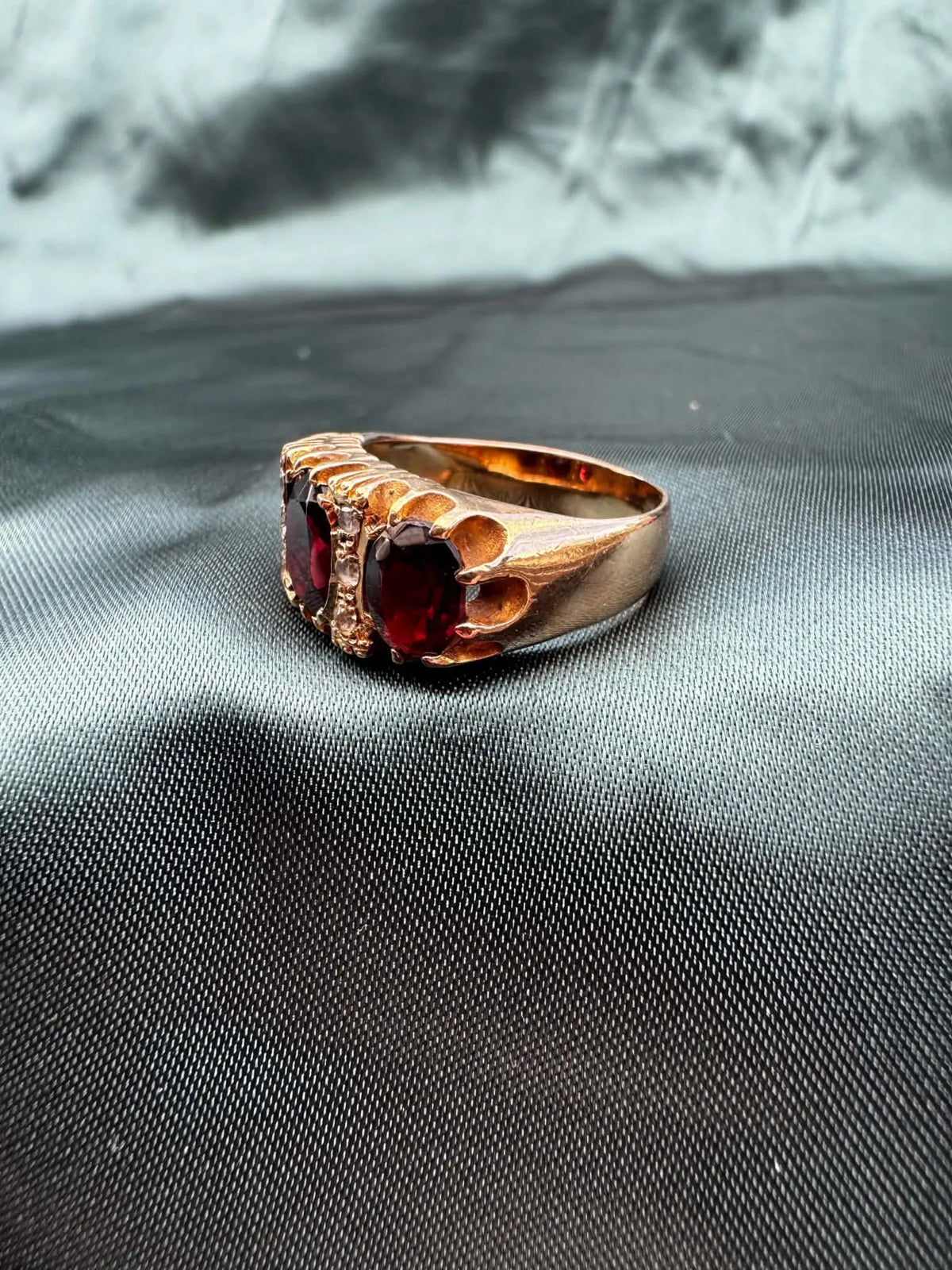 Garnet and paste three stone ring in 9ct gold, angled top view showing garnet and paste stones