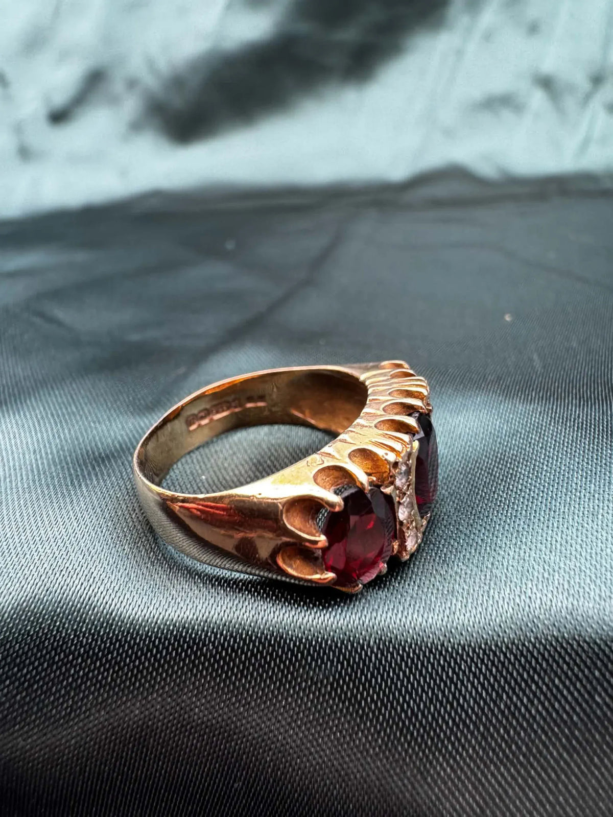 Garnet and paste three stone ring in 9ct gold, angled view showing garnet and paste stones