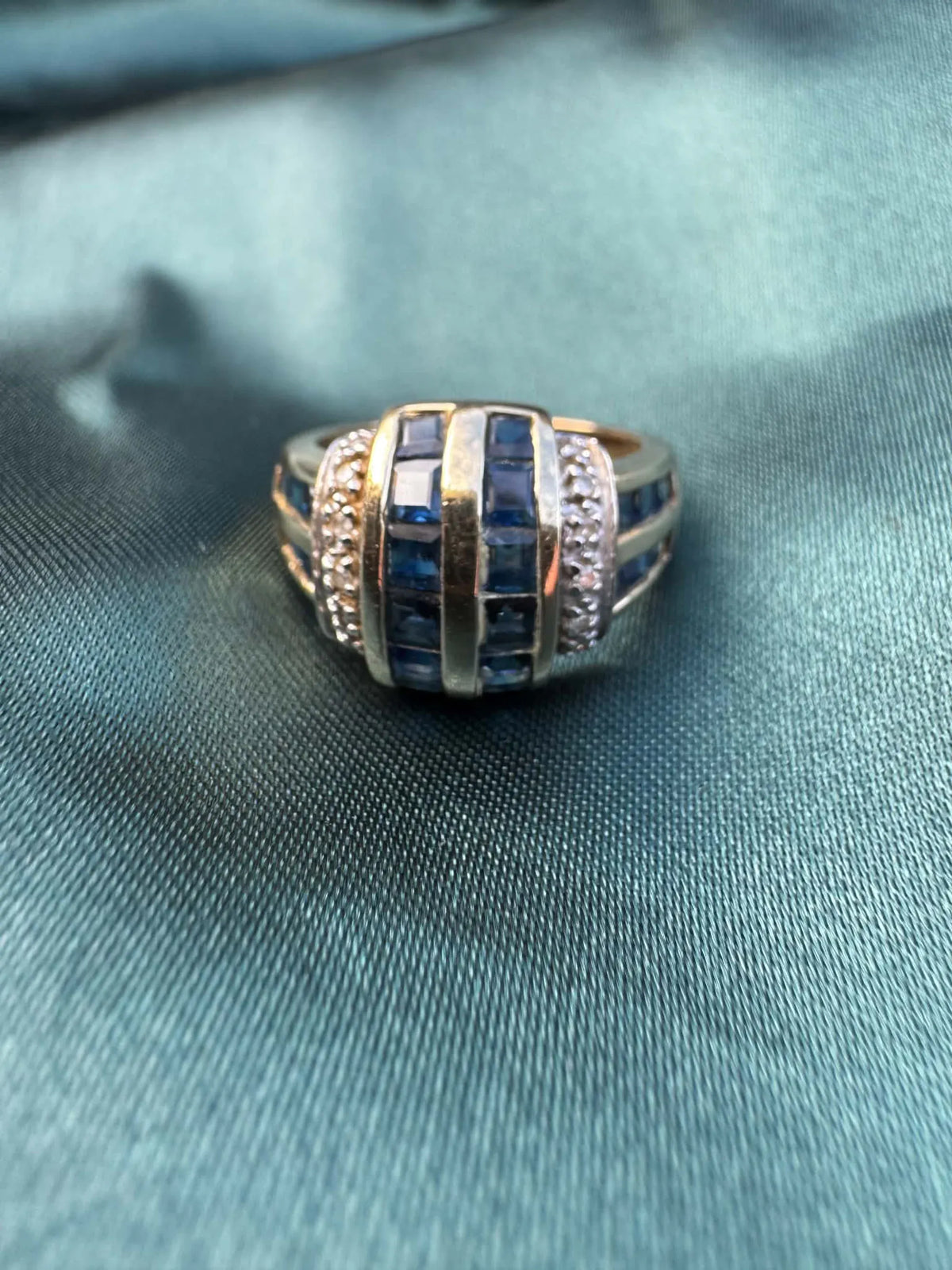 Sapphire and diamond dress ring in 9ct yellow gold, close-up angled top view showing sapphires and diamonds
