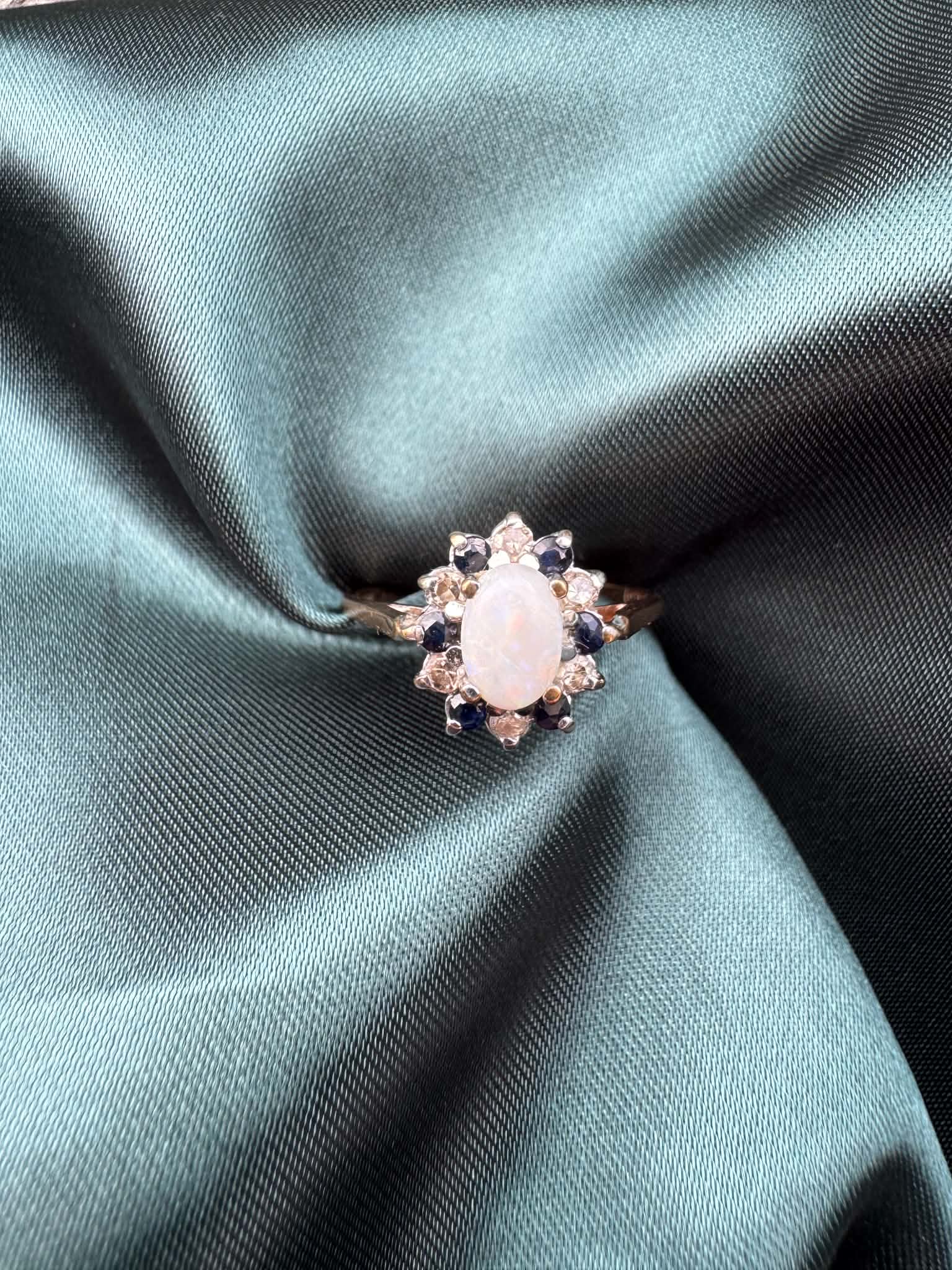 Opal, diamond and gem cluster ring in 9ct yellow gold, front view showing opal centre stone