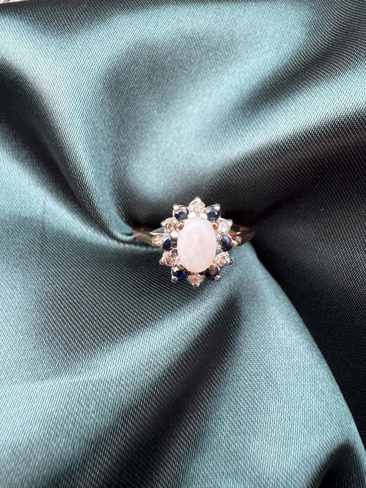 Opal, diamond and gem cluster ring in 9ct yellow gold, front view showing opal centre stone