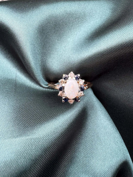 Opal, diamond and gem cluster ring in 9ct yellow gold, front view showing opal centre stone