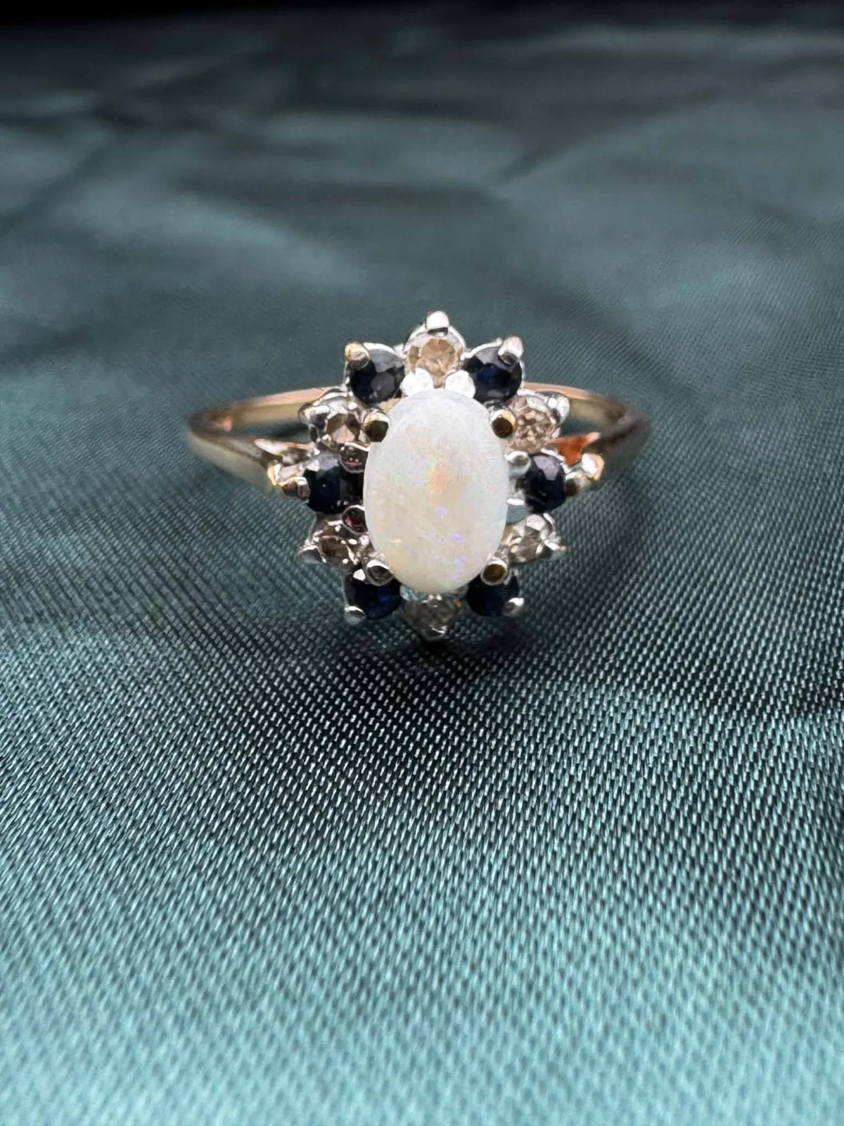 Opal, diamond and gem cluster ring in 9ct yellow gold, close-up of opal and surrounding stones