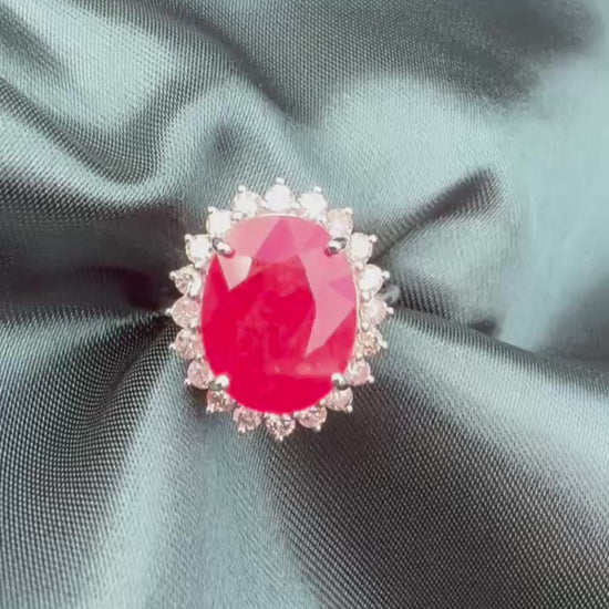 Ruby and diamond halo ring in platinum, front view showing oval ruby and diamond halo