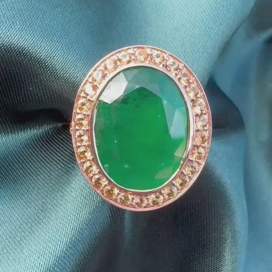 Emerald and orange sapphire cocktail ring in 14ct rose gold, front view showing oval emerald and sapphire halo